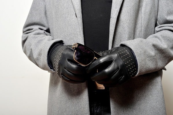 Personne chic munie de gants en cuir noirs.